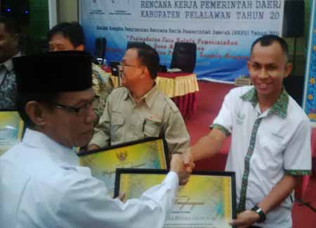 Koordinator CSR Asian Agri Wilayah Riau, Benjamin Hutagalung saat menerima penghargaan CSR Award.