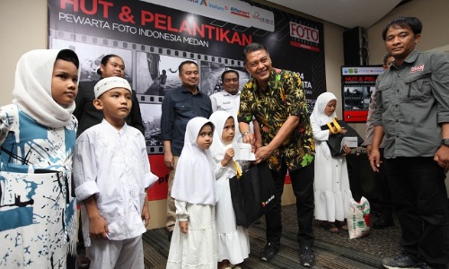 Head of Sales XL Axiata Greater Medan, Horas Lubis menyerahkan santunan untuk anak-anak yatim dan duafa.(foto: istimewa)