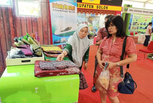 Pengunjung ketika melihat kain songket tenun lejo di stand Kabupaten Bengkalis, pada event Sumbar Expo 2019 di Kota Medan.