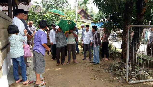 Kasubag Hubungan Media Hevi H Antoni saat berada dirumah duka didesa Pasar III, Kecamatan Natal