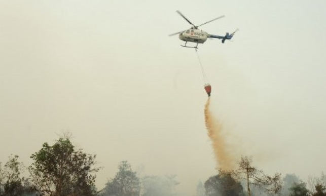 Helikopter Bolkow BO-105 dari Badan Nasional Penanggulangan Bencana (BNPB) melakukan water bombing di atas lahan gambut yang terbakar, di perkebunan sawit di Kecamatan Terentang, Kabupaten Kubu Raya, Kalbar, Rabu (21/10).  FOTO: Antara