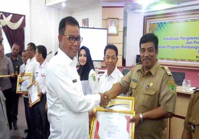 Bupati Suyatno memberikan sertifikat penghargaan kepada salah satu Datuk Penghulu yang berhasil mensukaskan program PTSL.