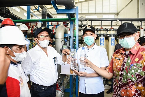Walikota Dumai H. Paisal memegang air minum hasil pengolahan dari IPA SPAM NUWSP kapasitas 50 liter per detik dengan Nano Filter.