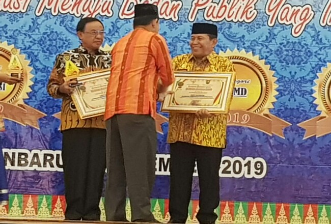 Bupati Sukiman, menerima penghargaan dari KI Rau setelah Kabupaten Rohul meraih nugerah Keterbukaan Informasi Badan Publik untuk Kategori Pemerintah Daerah Cukup Informatif dari KI Riau Award 2019.