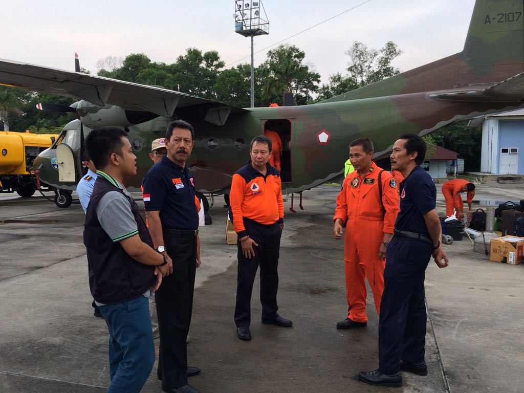 Kepala BPBD Riau, Edwar Sanger dengan latar pesawat cassa