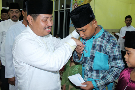 Bupati Bengkalis Amril Mukminin menyerahkan santunan kepada anak yatim saat safari Ramadhan ke Kecamatan Rupat