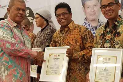  Ketua Dewan Kehormatan PWI Riau, Helmi Burman serahkan penghargaan kepada Regional Head Wilayah Riau Asian Agri Pengarapen Gurusinga.