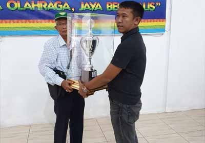 Ketua PASI Kabupaten Bengkalis, H Sanusi menyerahkan piala juara umum Kejurda Atletik di Pekanbaru kepada Ketua KONI Bengkalis Darma Firdaus Sitompul. 