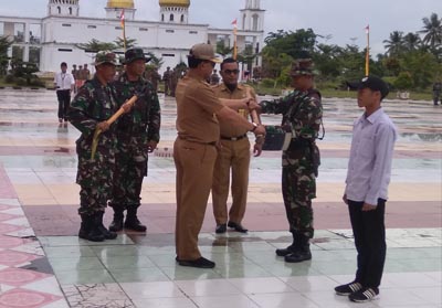 Bupati menyerahkan alat berupa cangkul dan sekop kepada perwakilan TNI dan masyarakat.