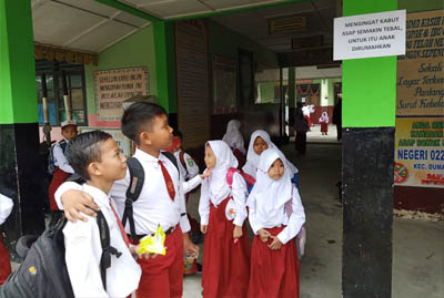  Pihak sekolah di SDN 022 Dumai memasang pengumuman merumahkan pelajar akibat kabut asap. FOTO: Bambang