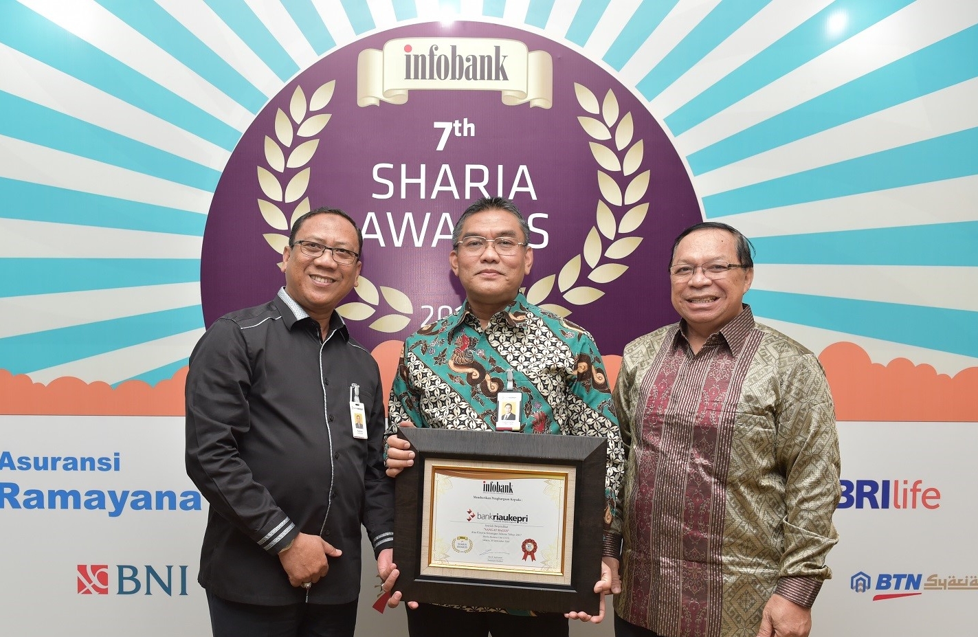   Dirut Bank Riau Kepri DR. Irvandi Gustari bersama Pemimpin Divisi Bisnis Syariah Syahrul dan Pemimpin Divisi Operasional dan Perencanaan Syariah Zaini Ahmad usai menerima Award predikat kinerja “Sangat Bagus” pada ajang 7th Infobank Sharia Awards 2018.