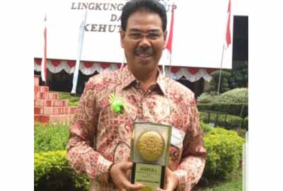 Kepala DLH Syamsul Anwar, SH. MH berfoto dengan Piala Adipura yang diraih Kota Pangkalan Kerinci Kabupaten Pelalawan