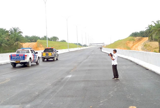 Seorang pegawai pemprov sedang melakukan pengecekan jalan tol Pekanbaru-Dumai. Jalan tol ini akan mengurai kepadatan arus kendaraan yang menghubungkan Pekanbaru-Dumai. FOTO: Gatra