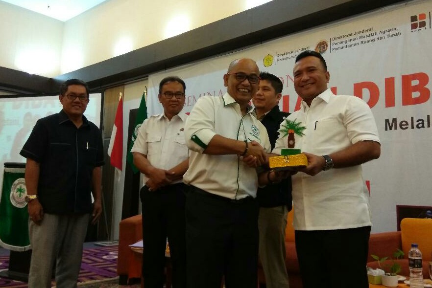 Ketua Apkasindo Riau, Gulat Medali Emas Manurung menyerahkan cinderamata kepada Wadir Reskrimsus, Edy Fariadi usai seminar 