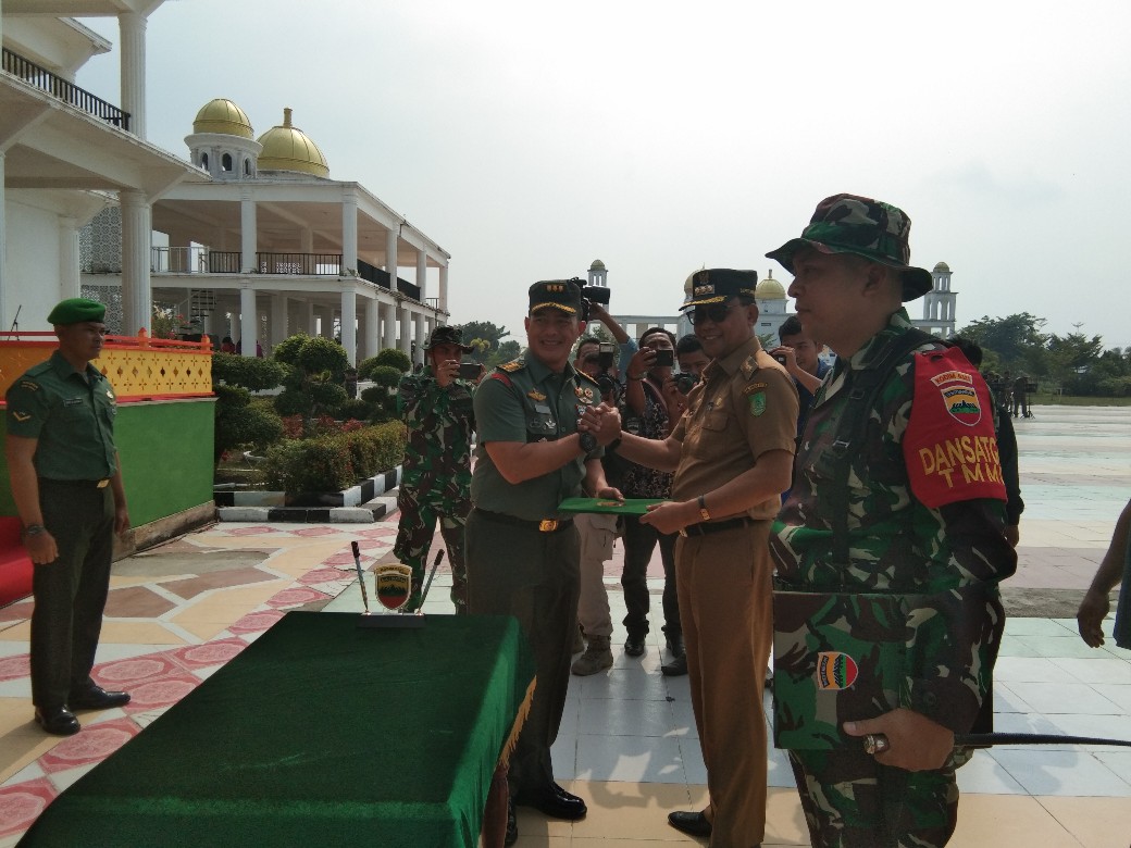 Kasrem 031/Wirabima, Kolonel Inf Asep Nugraha menyerahkan berita acara kepada Bupati Rohil, H Suyatno Amp saat penutupan TMMD ke 105, Ditaman Budaya, belum lama ini. 
