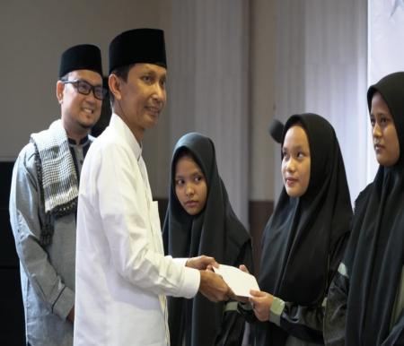 Pj Sekdaprov Riau Indra menyerahkan satunan untuk anak yatim di Masjid Raya An-Nur (foto/yuni)