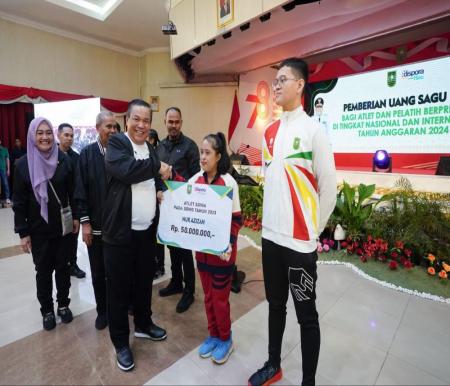 Pj Gubernur Riau, SF Hariyanto menyerahkan bonus kepada atlet Riau yang berprestasi.(foto: mcr)