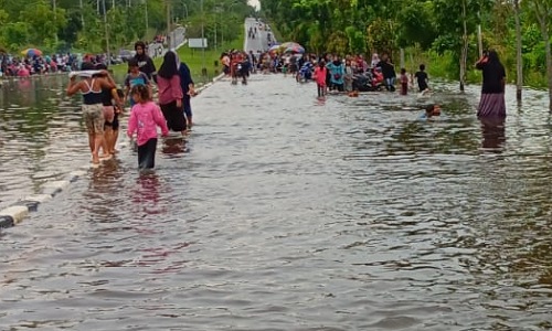 Anak-anak bermain air di lokasi banjir Jalan Bupati Pelalawan, Pangkalan Kerinci.(foto: barkah/halloriau.com)