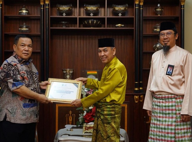 Penjabat (Pj) Gubernur Riau, SF Hariyanto menyerahkan penghargaan kepada lima OPD Provinsi Riau atas kategori kualitas tertinggi kepatuhan penyelenggara pelayanan publik pemerintah daerah 2023.
