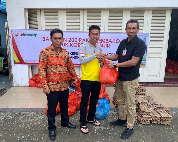 BM BRK Syariah Cabang Bagansiapiapi, Arrizal Saputra menyerahkan paket bantuan sembako untuk warga terdampak bencana banjir kepada Bupati Rohil, Afrizal Sintong di Kediamannya, Kamis (11/1/2024)