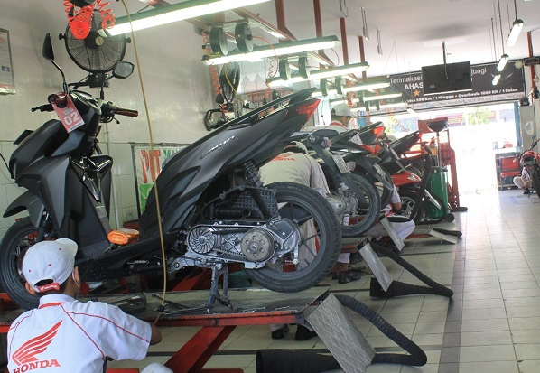 Mekanik AHASS sedang melakukan perawatan sepeda motor Honda