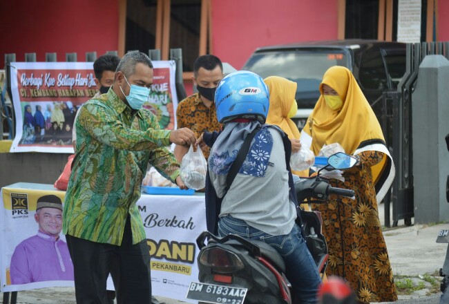 Ketua DPRD Pekanbaru membagikan makanan kepada masyarakat.