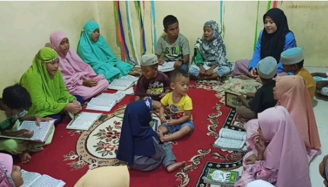 Mahasiswi Ilmu Komunikasi UIN Suska Riau Aprilisma mengajari anak mengaji.