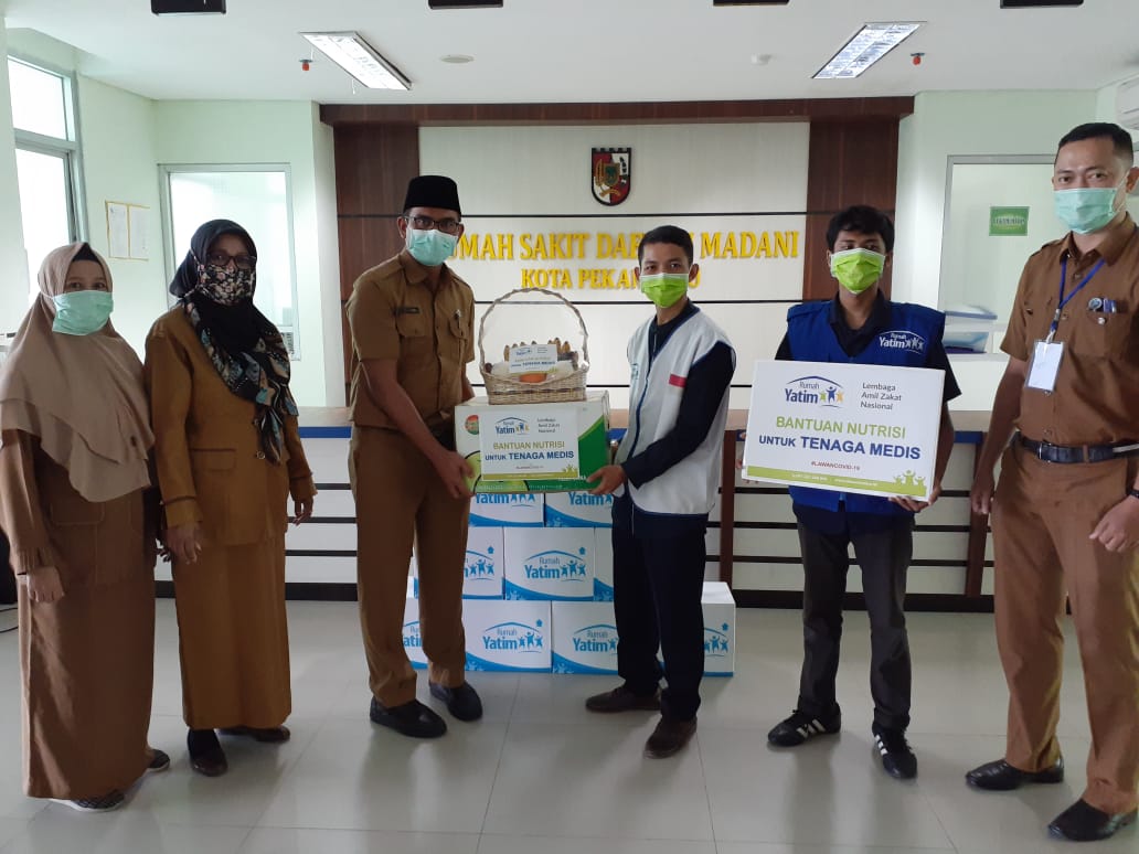 Penyerahan bantuan oleh Kepala Cabang Rumah Yatim Riau, Ramdan 