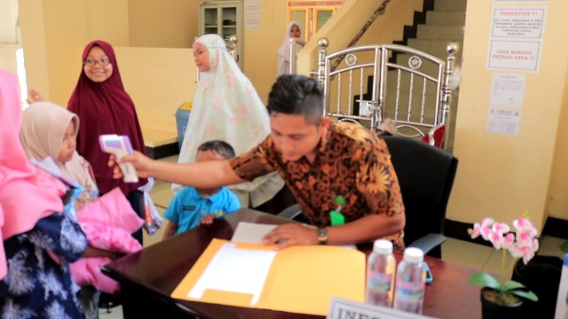 Petugas di Masjid Agung Islamic Centre Pasir Pangaraian, lakukan pemeriksaan suhu badan ke para pengunjung dengan alat Thermo Scanner, sebagai pengamanan peredaran virus Corona