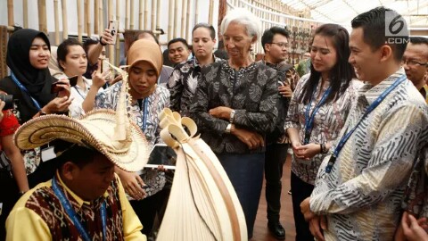 Managing Director IMF Christine Lagarde menyaksikan musikus memainkan sasando saat berkunjung ke Paviliun Indonesia di arena pertemuan IMF-Bank Dunia, Bali, Rabu (10/10). Christine terpesona dengan berbagai budaya Nusantara. Foto : Liputan6