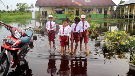 Pihak sekolah terpaksa mengaktifkan kembali proses belajar mengajar meskipun banjir masih merendam sekolah.  