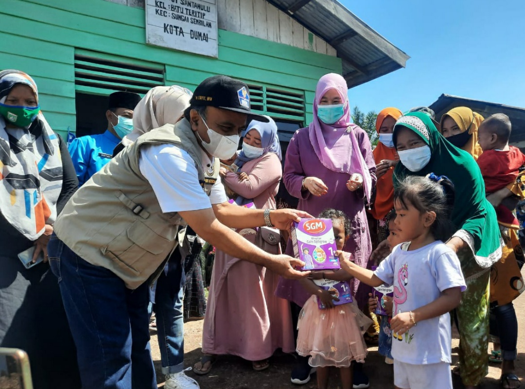 Plt Kepala Dinas Kesehatan Dumai Syaiful menyerahkan bantuan susu kotak kepada balita di Kelurahan Batu Teritib Kecamatan Sungai Sembilan.
