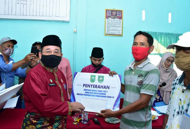 Plh Bupati Bengkalis menyerahkan BST bantuan Provinsi Riau secara simbolis.