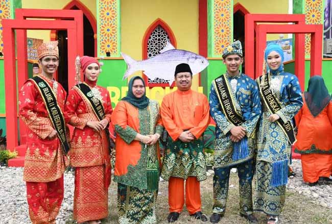 Bupati Amril Mukminin beserta istri Kasmarni berfoto bersama Bujang Dara ketika meninjau stan Kabupaten Bengkalis di MTQ ke-38 Riau. 