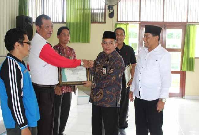 Kepala Kantor Urusan Agama Kecamatan Sentajo Raya H Jefri Eriadi saat menerima penghargaan.