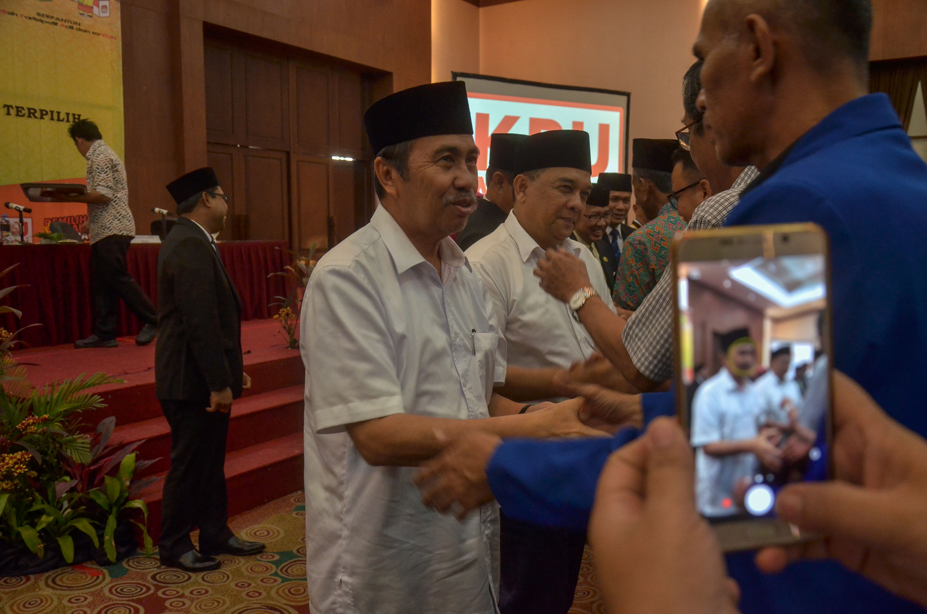Sejumlah kerabat dan pendukung memberikan selamat kepada pasangan Gubernur dan Wakil Gubernur Riau terpilih Syamsuar dan Edy Nasution saat rapat pleno terbuka yang gelar Komisi Pemilihan Umum (KPU) Riau di Pekanbaru, Riau, Selasa (24/7/2018). FOTO: Wahyudi