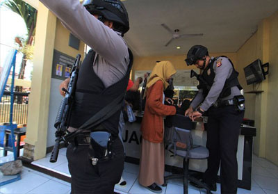 Petugas kepolisian memeriksa warga yang akan masuk ke Mapolres Indramayu, Jawa Barat