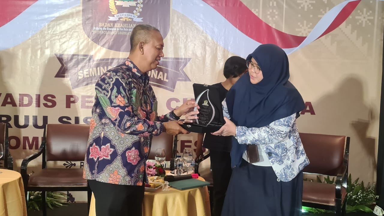 Rektor Universitas Islam Riau Prof Dr H Syafrinaldi Sofyan menerima cenderamata dari Analis Legislatif Ahli Muda Badan Keahlian DPR RI Dr. Ariesy Tri Mauleny.(foto: istimewa)