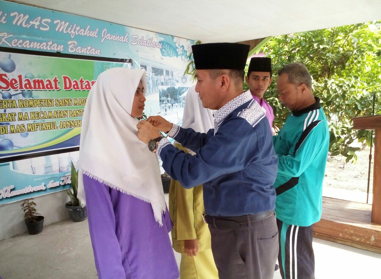 Kasi Pendidikan Madrasah Kemenag Kabupaten Bengkalis, memasang tanda peserta kepada salah seorang perwakilan siswi. 