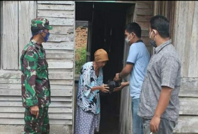 Personel TNI Koramil 08/Tandun dan perangkat desa juga tokoh masyarakat ,bagikan paket sembako ke warga kurang mampu terdampak COVID 19 di Desa Ujung Batu Timur, Kecamatan Ujung Batu.