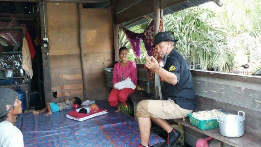 Kepala BPBD Pelalawan Hadi Penandio saat berbincang dengan warga. Foto : Tribun Pekanbaru