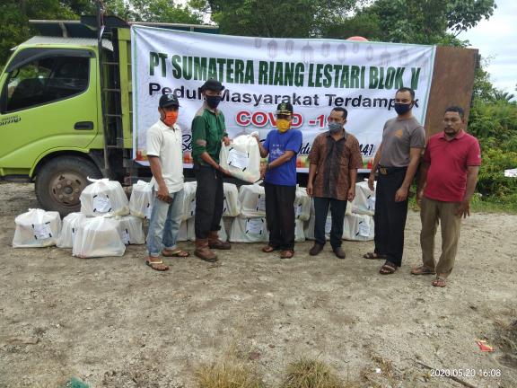 Eko Virgustin, Humas PT SRL Estate Rangsang memberikan paket nantuan kepada Kepala Desa Repan Kecamatan Rangsang Kabupaten Kepulauan Meranti disaksikan oleh Perangkat Desa, Rabu (20/5/2020).