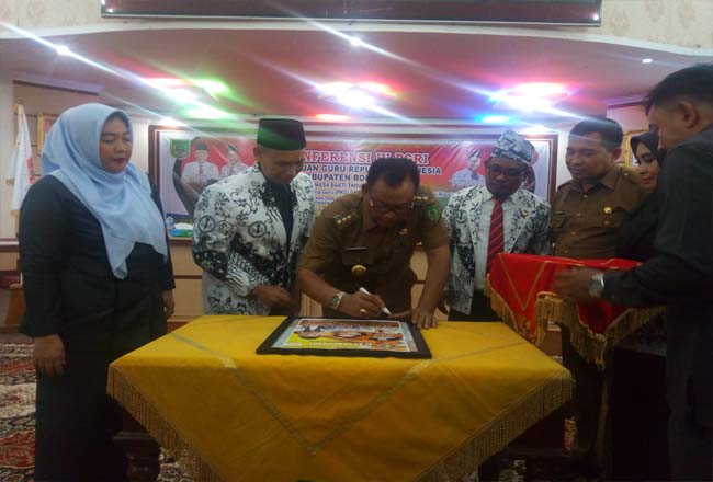Bupati Suyatno menandatangani launching majalah PGRI Riau.