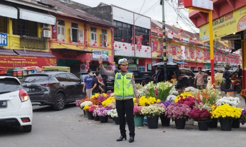 Kasatlantas Polresta Pekanbaru, Kompol Birgittha Atvina Wijayanti mengatur lalin di Jalan Juanda menuju Pasar Sago.(foto: bayu/halloriau.com)