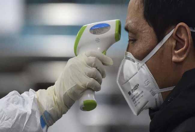 Petugas KKP Dumai mengukur suhu tubuh penumpang asal Malaysia saat turun di pelabuhan Internasional Dumai, Senin (27/1/2020).