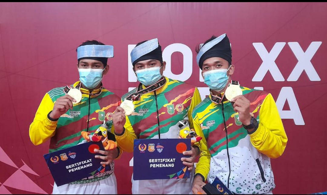Atlet anggar Riau M Fajri, M Fachrozi, dan Dwi Angga Mayudha menunjukkan medali emas yang diraih di nomor degen beregu putra pada PON XX di Papua, Sabtu (9/10). (Ist)