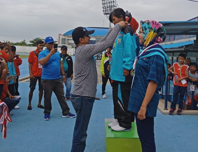 Kadisparbudpora Pelalawan, Andi Yuliandri S.Kom mengalungkan Medali Emas pada Atlit PEPARPEDA Kabupaten Pelalawan, pada cabang olahraga Atletik nomor lomba 200 meter putri. 