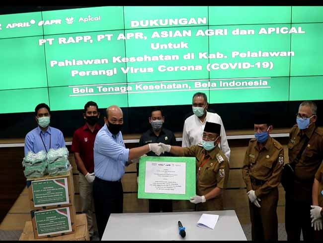   Direktur PT RAPP, Mulia Nauli, menyerahkan bantuan APD dari perusahaan ke Pemkab Pelalawan, yang langsung diterima oleh Bupati Pelalawan HM Harris.