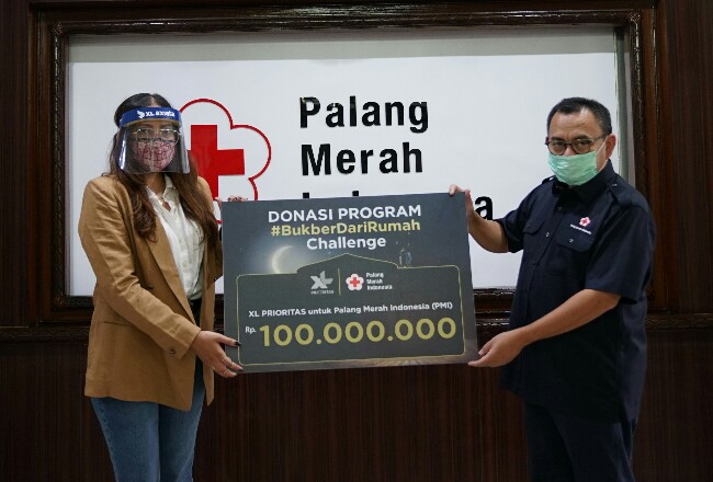 Head of Premium Marketing Communication XL Axiata, Aprilia Madonna ( kiri ) menyerahkan donasi kepada Palang Merah Indonesia, yang diterima oleh Sekjen PMI, Sudirman Said di Jakarta, minggu lalu.