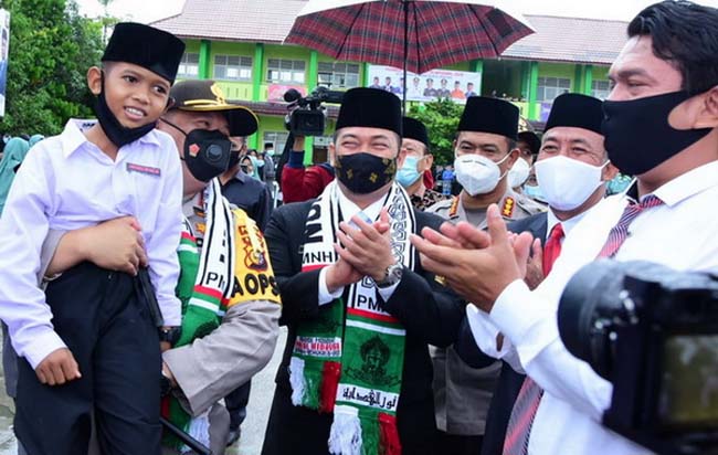 Kapolda Riau menggendong salah seorang  santri saat mengikuti kegiatan apel peringatan Hari Santri Nasional di PMNH Kecamatan Bantan Bengkalis.